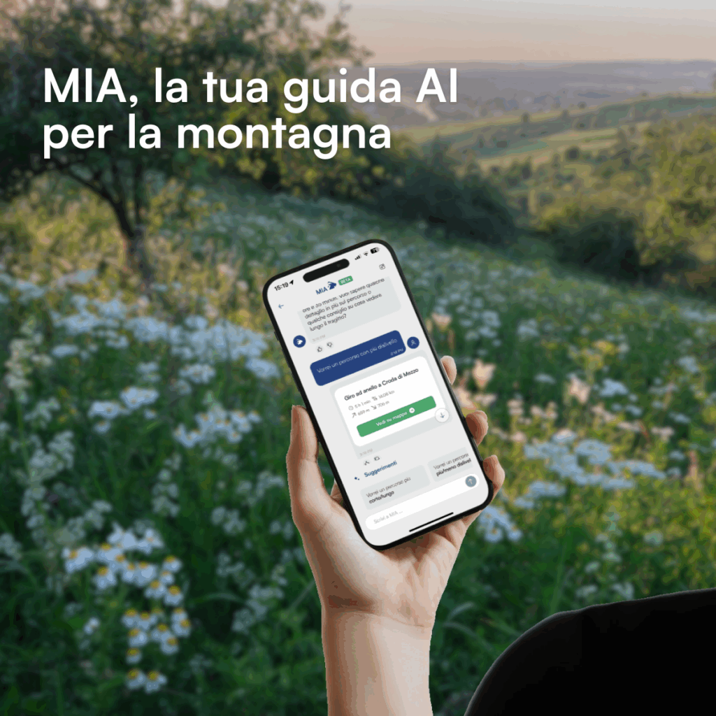 Ambiente di montagna e persona con in mano un telefono che scrive a MIA per chiederle cose di montagna